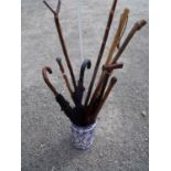 Blue & white ceramic stick stand containing a selection of various walking sticks, umbrellas,