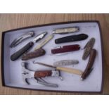 Tray containing a selection of various vintage and modern pocket knives