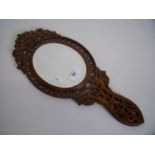 Late 19th C bevelled edged oval hand mirror with carved fretwork walnut frame, the back with