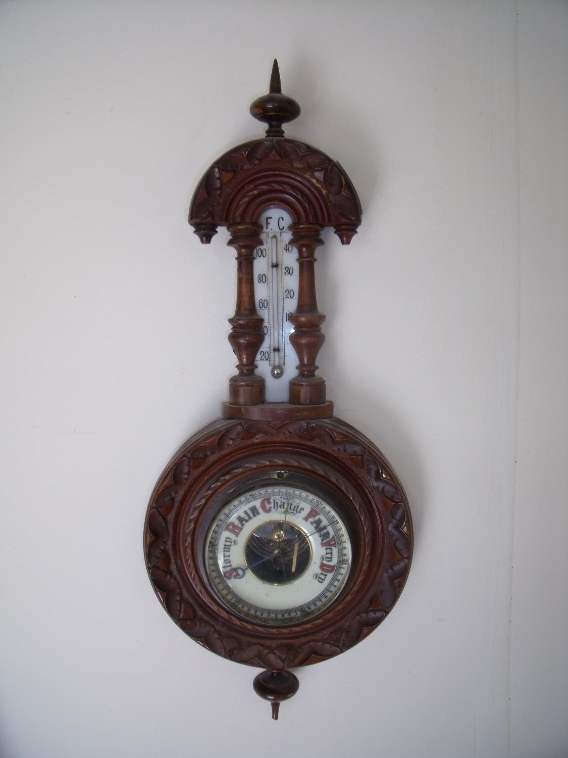Small carved beech framed aneroid wall barometer with milk glass thermometer plate (overall length