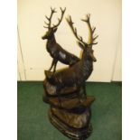 A large pair of bronze stags on rocky outcrops mounted on oval stepped marble bases (72cm high)
