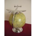 Modern terrestrial type globe with chrome figure of an airplane (height 33cm)