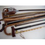 Collection of various assorted walking sticks, a shooting stick and copper coaching horn