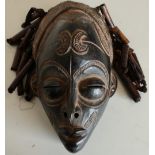 Carved African style tribal face mask with ribbon and beadwork hair