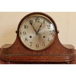 Early 20th C oak cased mantel clock with steel dial on four raised bun feet, the chiming movement