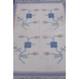 Heavy cotton rug, blue grey ground with four stylised flowers in central panel (180cm x 128cm)