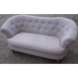 Modern Victorian style two seat sofa with upholstered seat and deep button back, on light wood