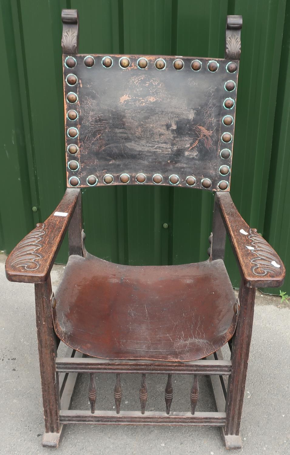 19th/20th C Baronial style carved oak armchair with leather seat and back, and heavy studded detail