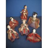 Collection of six Japanese dolls depicting various figures in seated and standing positions, with