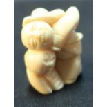 Edo period Japanese carved ivory Netsuke of three crappling Buddha's with signature to the base (