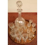 Cut glass bulbous decanter, set of six glasses and a set of seven glasses on circular wooden tray