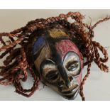 Small African style carved wood face mask with painted detail and hessian ropework hair