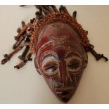 Large carved African style carved tribal face mask with highlighted detail, hessian ropework, ribbon