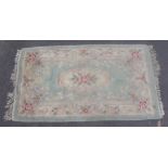 20th C Chinese washed woollen rug, green ground with central floral medallion and pattern border (