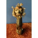 New Guinea carved and painted wooden tribal figure fixed with human teeth and feathers mounted to