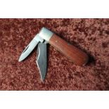 Twin bladed pocket knife with two piece wooden grips