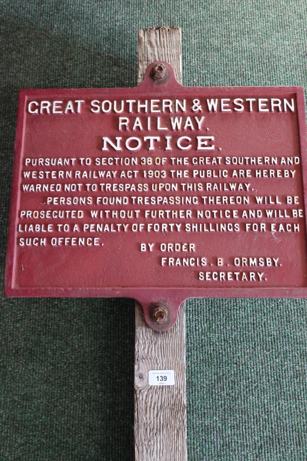 Wooden post mounted with a cast metal railway notice for Great Southern and Western Railways Act