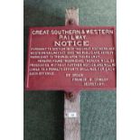 Wooden post mounted with a cast metal railway notice for Great Southern and Western Railways Act