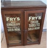 Early 20th C cabinet enclosed by two glazed cupboard doors with painted stenciled detail for Fry's