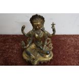 Signed oriental gilt bronze figure of a seated deity, set with various hard stones and signature