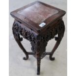 Carved Chinese hardwood stand with inset panel and elaborate carved detail on X shaped under