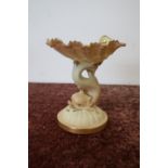 Small Royal Worcester comport in the form of a clam shell supported by a dolphin on circular base,