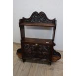 Carved oak wall shelf with raised swan neck pediments above shelf and open centre, above heavily