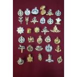 Box containing approximately fifty military cap badges for various regiments including Staybright