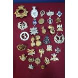 Box containing a quantity of various military cap badges, mostly staybright, for various regiments