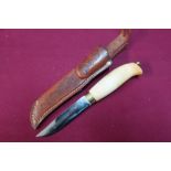 Sheath knife with 4 inch blade marked RUSLETTO with wooden grip and tooled tan leather sheath