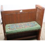 19th/20th C stained pine church pew of small proportions with panelled detail, brass hanging rail