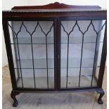 Mahogany display cabinet enclosed by two glazed doors on ball & claw feet (120cm x 40cm x 130cm)