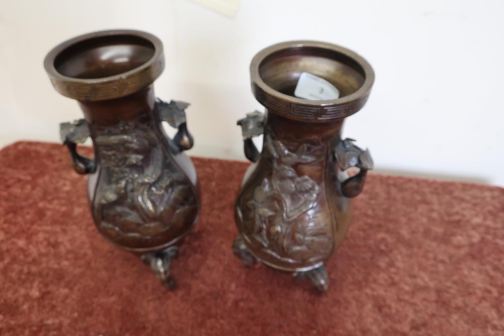 Pair of Japanese bronze vases on elephant head supports, with floral panel detail to the bodies (