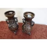 Pair of Japanese bronze vases on elephant head supports, with floral panel detail to the bodies (