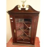 Mahogany corner cupboard with glazed front and brass escutcheon, with brass eagle and ball finial (