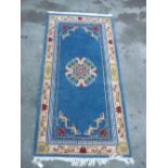 Chinese embossed washed woollen rug blue ground with central medallion and Greek key pattern