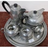 Five piece Sheffield pewter tea service with hammered detail on circular tray, with a pewter ladle