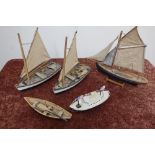 Wooden scale model of a rowing boat, three models of fishing boats and a tin-plate model of an
