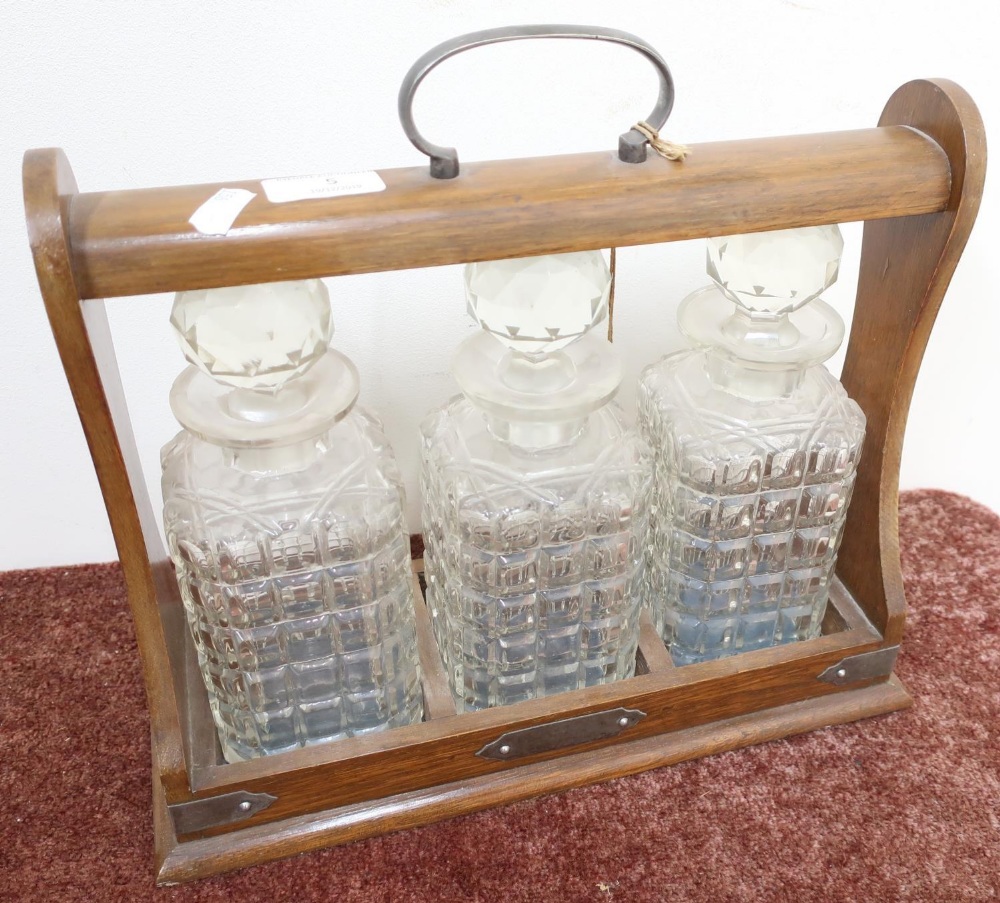 Mid - late 20th C oak three sectional Tantalus, with three glass decanters