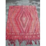 Traditional red ground Middle Eastern wall hanging with central diamond patterned medallion with