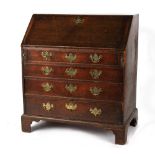 Property of a gentleman - a George III oak fall-front bureau, with four long graduated drawers, on