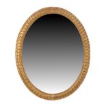 Property of a gentleman - an early 20th century gilt oval framed wall mirror, 29.35ins. (74.5cms.)