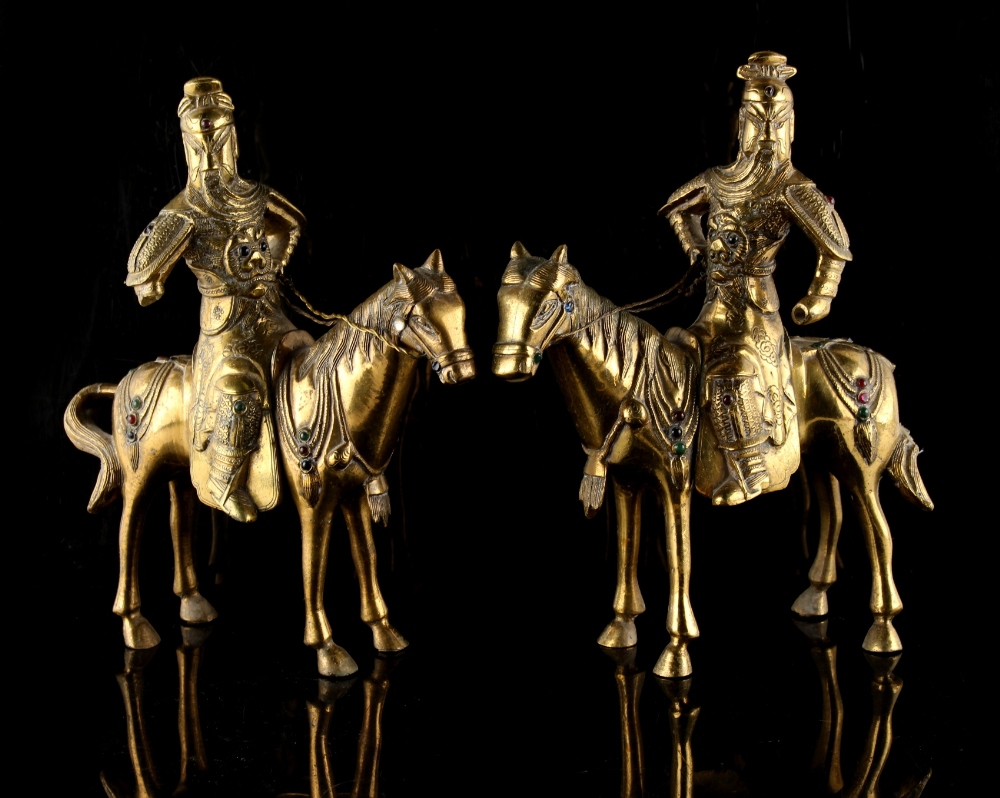 Property of a lady - a pair of Chinese polished bronze models of warriors on horseback, each inset