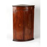 Property of a gentleman - a George III mahogany & inlaid bow-fronted two-door corner wall cabinet,