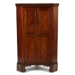 Property of a deceased estate - a George III mahogany panelled two-door corner cabinet, on bracket