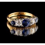 An 18ct yellow gold sapphire & diamond five stone ring, set with a row of three round cut