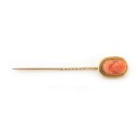 Property of a lady - a stickpin with carved coral oval panelled terminal depicting a classical