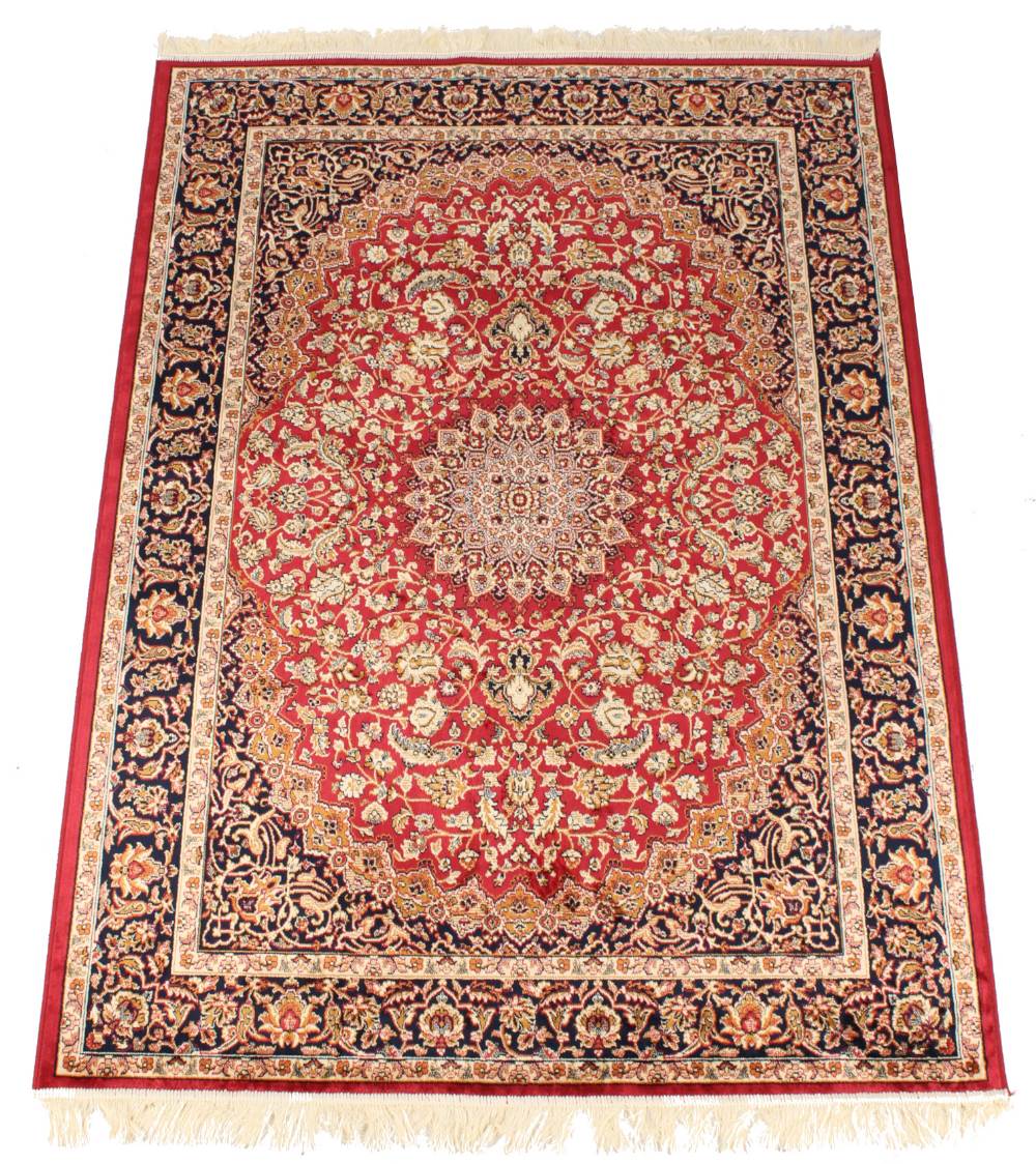 A Kashan style rug with red ground, 75 by 53ins. (190 by 135cms.) (see illustration).