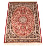 A Kashan style rug with red ground, 75 by 53ins. (190 by 135cms.) (see illustration).