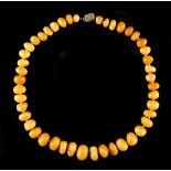 Property of a deceased estate - a butterscotch amber graduated pebble bead necklace, the largest